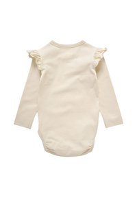 Lys beige langærmet bodystocking i blødt bomuld. Har rynkede detaljer på skuldrene og trykknapper i bunden for nem påklædning.