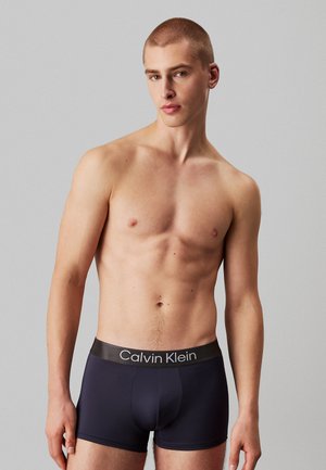 Bóxer ajustados de Calvin Klein en gris oscuro con una cinturilla elástica contrastante que presenta el logo de la marca, tejido suave y un diseño ceñido.