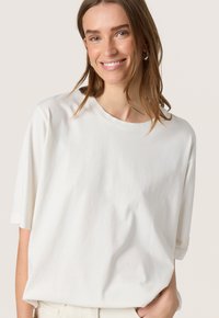 Hvid bomulds T-shirt med rund halsudskæring og korte ærmer, med en afslappet pasform og blød tekstur, båret afslappet.