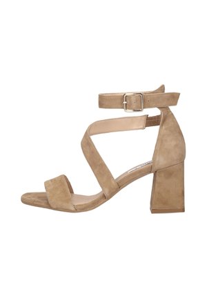 Beige suède sandaal met blokhak, enkelbandje met gesp, brede teenband en gekruiste banden voor ondersteuning.