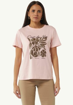 Lichtroze katoenen t-shirt met een ronde hals, met een donkergroene bloemenprint en de tekst "C'est la Vie" stylized erboven.