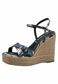 Wedge sandal with a patterned fabric upper in blue, white, and gray. Features a jute-wrapped platform and an adjustable ankle strap.