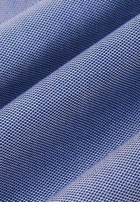 Niebieska i biała tkanina o wzorze, z fakturowanym splotem, z motywem w kratkę, który podkreśla głębię i wymiar.