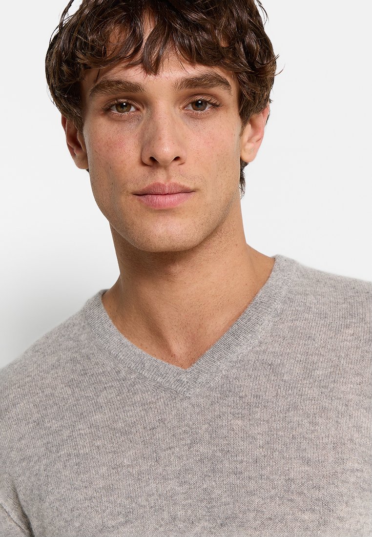 Grau V-Ausschnitt Pullover mit weicher Textur und leichtem Design. Hat einen einfachen, klassischen Schnitt, der sich zum Schichten oder als eigenständiges Kleidungsstück eignet.