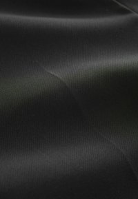 Černá texturovaná tkanina s hladkým, mírně lesklým povrchem, vykazující jemné vlnové vzory a jednotný matný povrch.