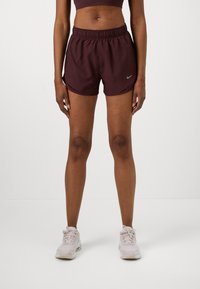 Bordeauxfarbene Sportshorts mit elastischem Bund und seitlichen Schlitzen. Mit einem kleinen grauen Nike-Logo auf der linken Seite. Leichtes Material.