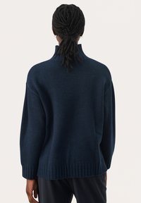 Navyblauwe gebreide trui met een hoge kraag, ontspannen pasvorm, geribbelde zoom en lange mouwen, met een gestructureerde stof.