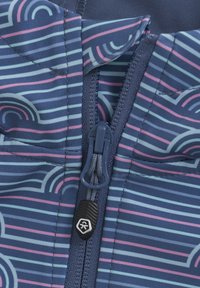 Blå mønstret stof med horisontale striber i pastelfarver. Lynlås lukning med en tekstureret trækflap; afslappet krave-design.