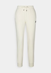 Cream-colored sweatpants with an elastic waistband, drawstring, and a small black Nike logo on the left side. Cuffed at the ankles.