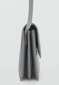 Portafoglio in pelle grigio chiaro con un design compatto, dotato di più scomparti a fisarmonica e una chiusura con zip sicura.
