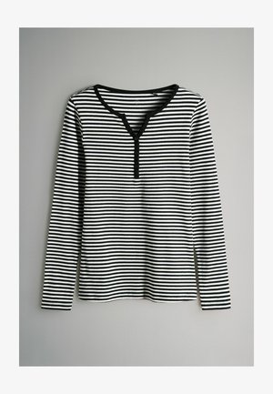 Dlhý rukáv pruhovaný top v čiernej a bielej farbe, s výstrihom do V a gombíkovými detailmi, ribovanou textúrou a rovnou spodnou časťou.