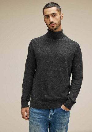 Suéter de cuello alto gris oscuro en un tejido texturizado, diseño ajustado con mangas largas, combinado con jeans azules. Apariencia simple y moderna.