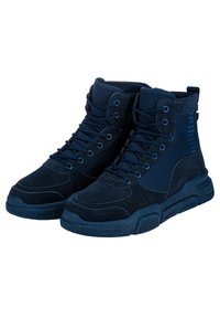 Baskets montantes bleu marine en matériaux suede et toile, dotées d'œillets en métal, de lacets plats et d'une semelle texturée, avec un logo sur le côté.