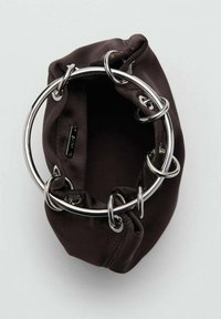 Bolso tipo bucket de tela marrón con parte superior fruncida, que presenta grandes anillos metálicos plateados como acentos. Textura suave, forma compacta, sin cierre visible.