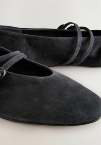 Zwarte suede balletschoenen met een amandelvormige neus, met een dubbele band over de voet en een gladde, matte textuur.