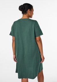 Short-sleeve, knee-length dress in dark green cotton. Features a relaxed fit with a crew neckline and rolled sleeves. No visible patterns.
