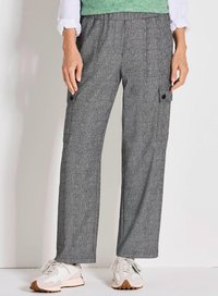 Grijze, gestructureerde cargobroek met een losse pasvorm, voorzien van zijzakken en een zwarte knoopdetails. Gepaard met witte sportschoenen.