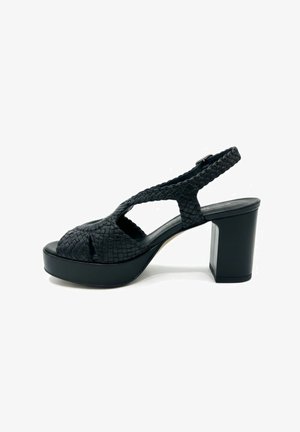 Sandalo nero con tacco alto con cinturini intrecciati, punta aperta, design slingback e tacco alto spesso su sfondo bianco.