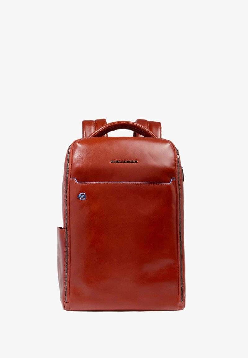 Mochila de cuero roja con una textura suave, bolsillo frontal con cremallera y detalle del logo. Presenta correas de hombro ajustables y un bolsillo lateral.