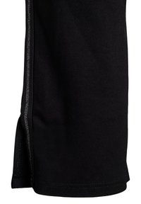 Zwarte sportshorts van een gladde stof, met een zilveren streep langs de zijkant en korte zijsplitten aan de onderkant voor meer bewegingsvrijheid.