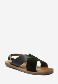 Sandale en cuir noir et daim vert avec un design à bout ouvert. Dotée d'une bride de cheville ajustable et d'une semelle intérieure rembourrée pour plus de confort.