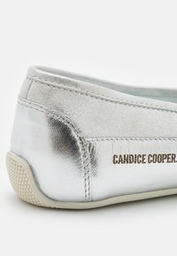 Scarpa slip-on in pelle argentata metallizzata con finitura testurizzata, suola in gomma bianca e nome del brand impresso sul lato.