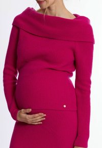 Fuchsia gerippter Pullover mit einem schulterfreien Ausschnitt und langen Ärmeln; mit einem kleinen goldenen Hardware-Akzent in der Nähe der Taille.