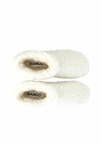 Vita fleeceinspirerade tofflor med en mjuk, strukturerad yta och stängd baksida. Inuti finns en logotypetikett med namnet "BIANCO."