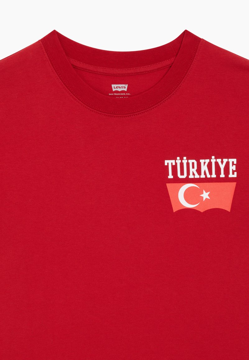 Crvena Levi's majica s natpisom "TÜRKİYE" iznad crvenog Levi's logotipa s motivom polumjeseca i zvijezde.