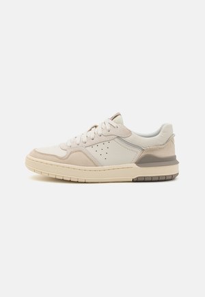Sneaker aus hellem Creme- und braunem Wildleder, mit alternativer Schnürung, durchlöcherten Details und einer strukturierten Gummisohle für besseren Halt.