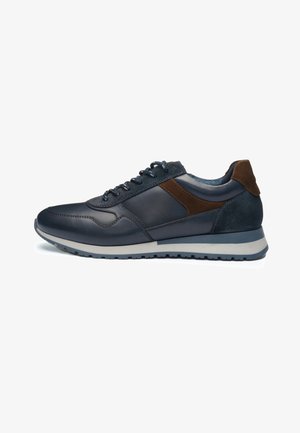 Donkerblauwe casual sneaker met bruine suède accenten, veters aan de voorkant en een witte zool met een getextureerd zwart profiel.