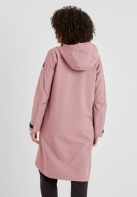 Pink waterproof jacket with a hood, long sleeves, and adjustable cuffs. Smooth texture and minimalistic design, back view displayed.