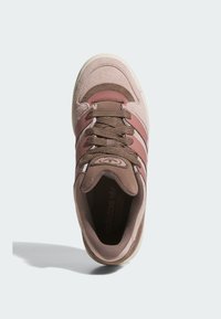 Svijetlo ružičasti tenisice s smeškim akcentima, od antilopa i tekstilnih materijala, okrugli vrh, logo s tri pruge i teksturirane vezice. Ravni gumeni potplat.