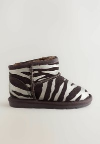 Stivaletto a fantasia zebra con camoscio marrone e strisce metalliche argento. Fodera morbida e silhouette a profilo basso. Punta rotonda con dettagli cuciti.