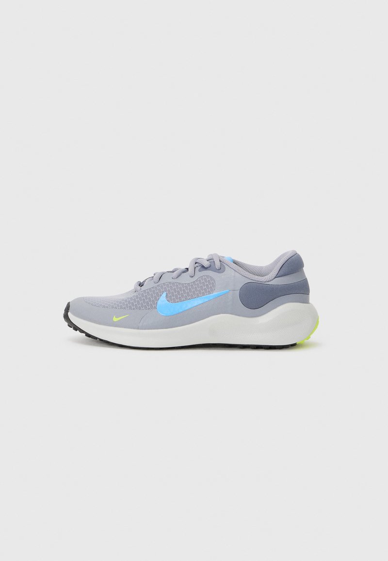 Baskets de sport gris clair avec un swoosh Nike bleu, tige en mesh, semelle en caoutchouc et accent jaune au niveau du talon. Présente un design rembourré.