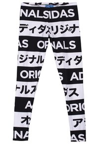 Černobílé legíny s alternujícími horizontálními pruhy, které mají výrazný text "ADIDAS ORIGINALS" v angličtině a japonských znacích.