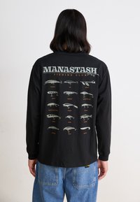 Black long-sleeve shirt featuring "MANASTASH FISHING CLUB" text and illustrations of fishing lures in various shapes and colors on the back.