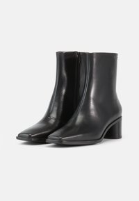 Mustad nahast pahkluu saabaste ruudukujulise ninaosaga, peened õmblused, külgmine tõmblukk ja madal plokk-kanna.