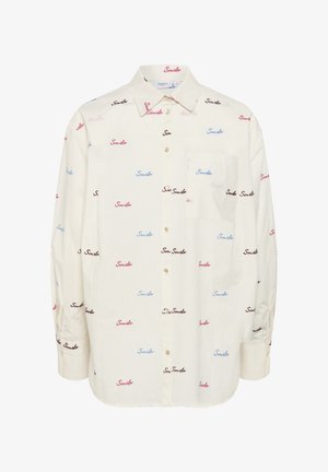 Camisa blanca de botones con un bolsillo, fabricada en tejido ligero, impresa con la palabra "Sonríe" en texto manuscrito de color rosa, azul y negro.