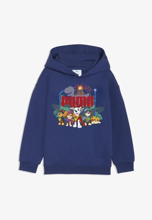 Felpa con cappuccio blu navy con personaggi di Paw Patrol e logo PUMA rosso sotto la silhouette di un vulcano e un dinosauro.
