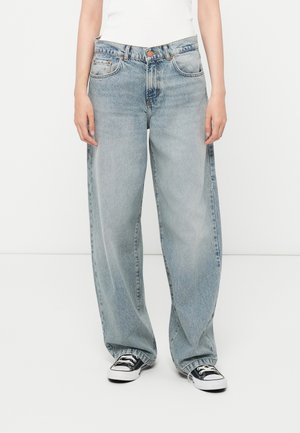 Light blue wide-leg jeans made from denim, featuring a high waist and front pockets. Paired with black and white sneakers.