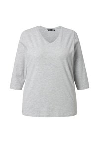 Maglietta grigia a maniche lunghe con scollo a V, realizzata in tessuto morbido, presenta un delicato dettaglio a forma di cuore sul petto e una vestibilità comoda.