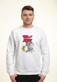 Biała bluza z kolorową grafiką przedstawiającą Toma i Jerry'ego. Projekt podkreśla postacie z kreskówek z wyraźnymi czarnymi konturami i żywymi kolorami.