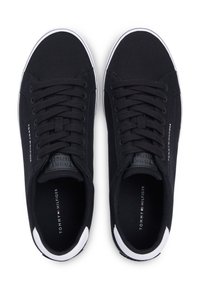 Μαύρα πάνινα παπούτσια με στρογγυλή μύτη, λευκή καουτσούκ σόλα και λευκή λεπτομέρεια στη φτέρνα. Διαθέτουν μαύρα επίπεδα κορδόνια και λογότυπο στο πλάι.