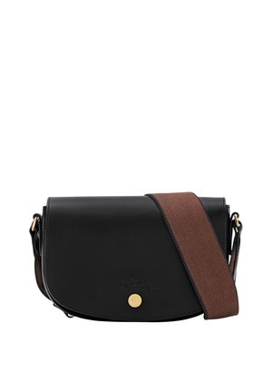Black leather crossbody bag with curved flap, gold button closure, and wide textured brown shoulder strap.