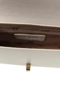 Clutch in pelle bianca testurizzata con chiusura a morsetto dorato. L'interno presenta una fodera beige con un motivo a logo e una tasca con zip.
