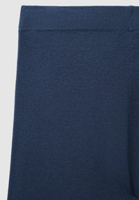 Dunkelblaue Leggings mit einer glatten, dehnbaren Textur. Der Bund ist elastisch und es sind keine sichtbaren Nähte oder Muster vorhanden.