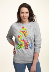 Šedá mikina s barevnými kreslenými medvědy lezoucími po duze v hravém designu. Měkká textura, kulatý výstřih a žebrované manžety.