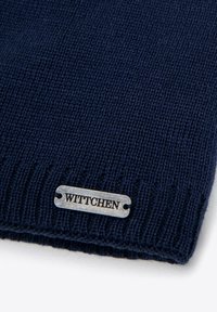 Granatowa dzianinowa czapka z metalową srebrną metką z wygrawerowanym napisem „WITTCHEN”, prezentująca teksturowany wzór i dopasowany krój.