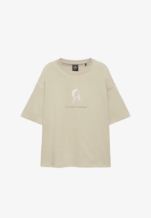 Beiges Oversize-T-Shirt mit verblasstem Porträt einer Frau und dem Schriftzug „JOHANNES VERMEER“ unter dem Bild.